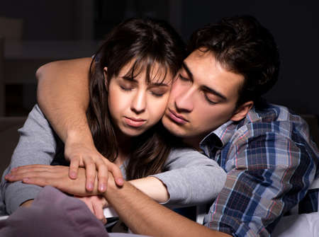 Young parents sleepless with newborn baby at nightの写真素材