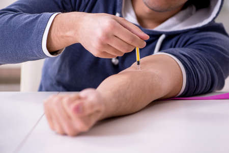 Young man having problems with narcotics at home