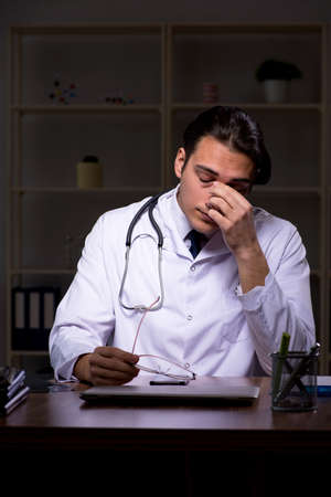 Young male doctor in the hospital at nightの写真素材