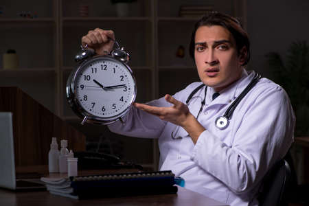 Young male doctor in the hospital at nightの写真素材