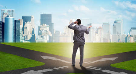Young businessman at crossroads in uncertainty concept