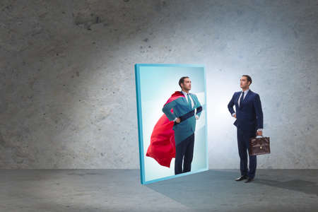 Businessman seeing himself in mirror as superhero