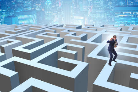 Businessman trying to escape from mazeの写真素材