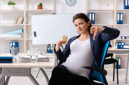 Old pregnant woman working in the officeの写真素材