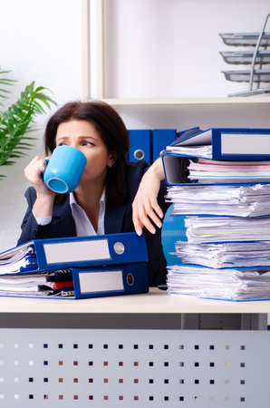 Middle-aged businesswoman unhappy with excessive workの写真素材