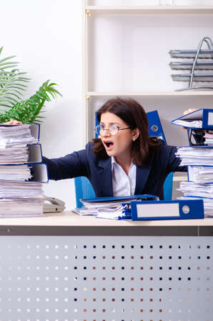 Middle-aged businesswoman unhappy with excessive workの写真素材