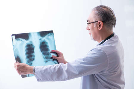Old male doctor working in the clinic