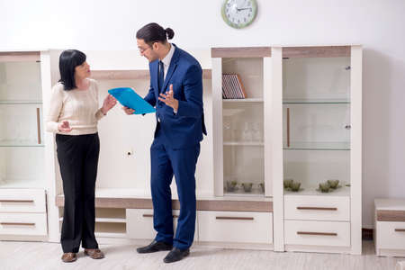 Male real estate agent and female client in the apartmentの写真素材