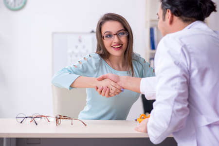 Young woman visiting male doctor oculistの写真素材