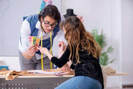 Young male tailor teaching female student