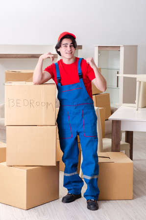 Young male contractor with boxes working indoorsの写真素材