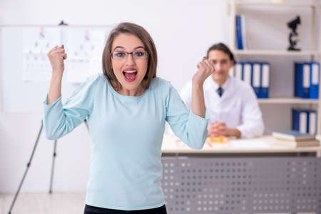 Young woman visiting male doctor oculistの写真素材