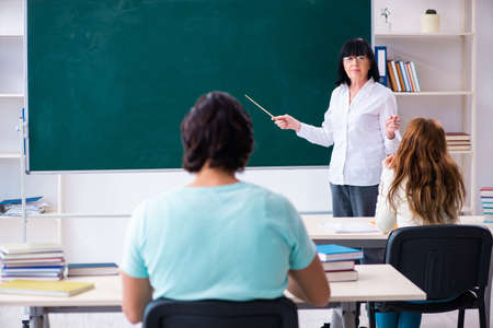 Old teacher and students in the classroomの写真素材