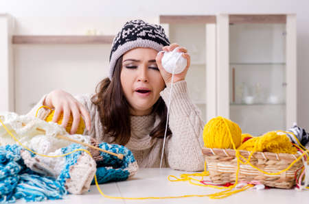Young beautiful woman knitting at homeの写真素材