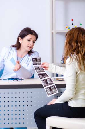 Young pregnant woman visiting experienced doctor gynecologistの写真素材