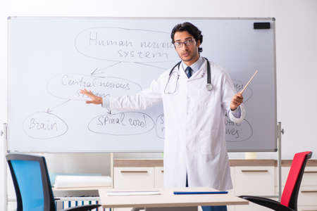 Young male doctor neurologist in front of whiteboardの写真素材