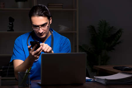 Young male doctor in the hospital at nightの写真素材