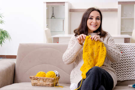 Young beautiful woman knitting at homeの写真素材