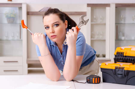 Young woman repairing chair at homeの写真素材