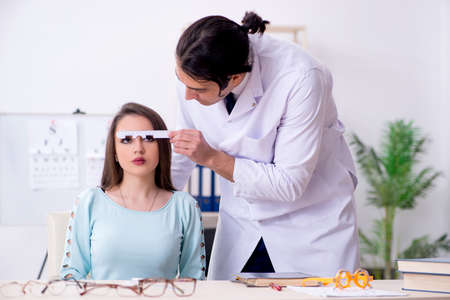 Young woman visiting male doctor oculistの写真素材