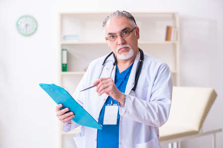 Old male doctor working in the clinicの写真素材