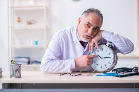 Old male doctor working in the clinicの写真素材