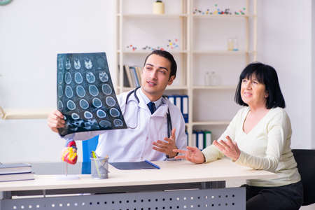 Young doctor examining senior old woman