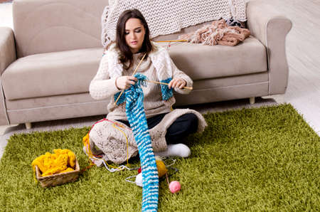 Young beautiful woman knitting at home