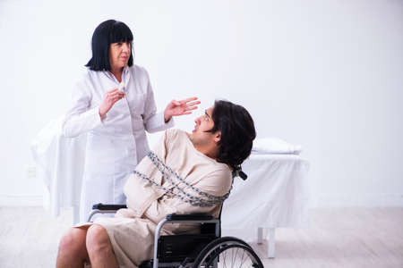 Old female psychiatrist visiting young male patientの写真素材