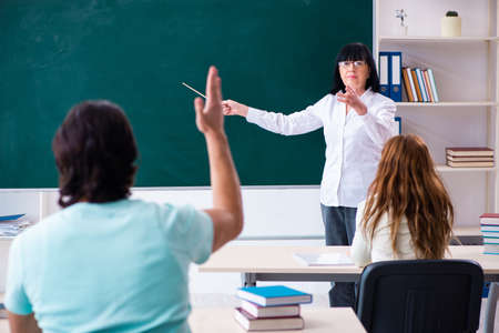 Old teacher and students in the classroomの写真素材