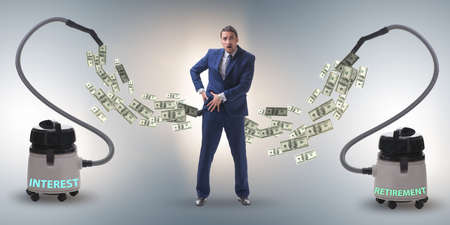 Businessman and vacuum cleaner sucking money out of himの写真素材