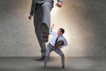 Bad angry boss kicking employee in business conceptの写真素材