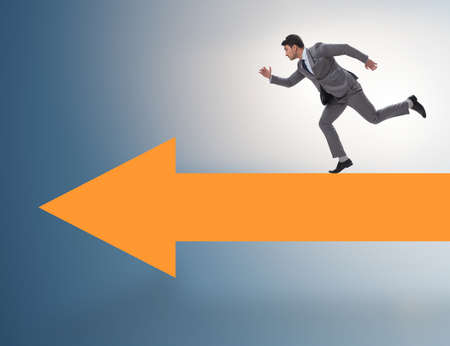 Businessman walking on arrow in business conceptの写真素材