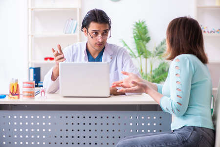 Middle-aged woman visiting male doctor stomatologistの写真素材