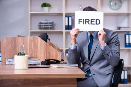 Young male employee being fired from his workの写真素材