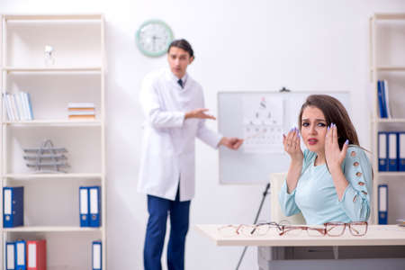 Young woman visiting male doctor oculistの写真素材