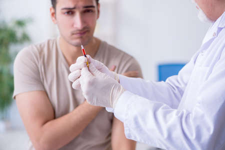 Male patient visitng doctor for shot inoculationの写真素材