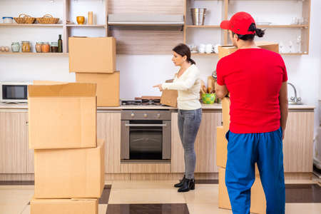 Young male contractor and female customer in moving conceptの写真素材