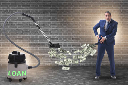 Businessman and vacuum cleaner sucking money out of himの写真素材