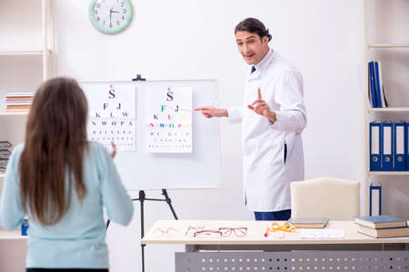 Young woman visiting male doctor oculistの写真素材