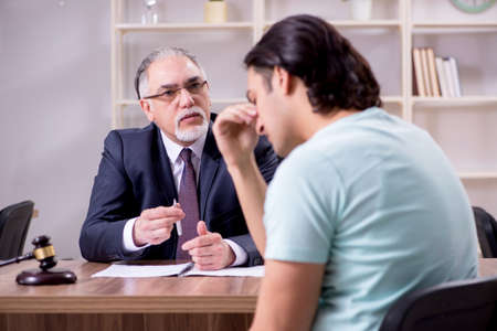 Young man visiting experienced male lawyerの写真素材