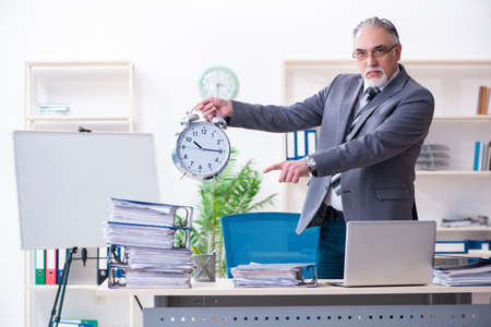 Aged male employee unhappy with excessive workの写真素材