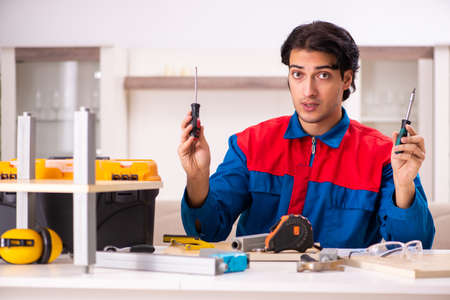 Young contractor repairing furniture at homeの写真素材