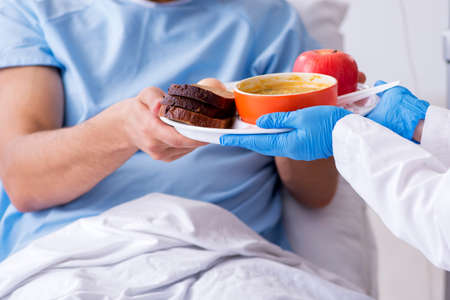 Male patient eating food in the hospitalの写真素材