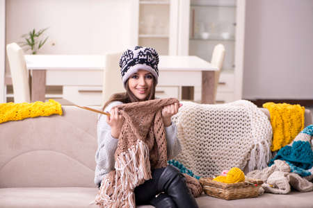 Young beautiful woman knitting at home