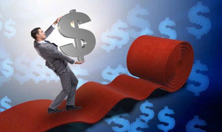 Businessman with dollars on red carpetの写真素材