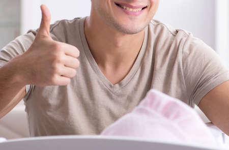 Young father enjoying time with newborn baby at homeの写真素材