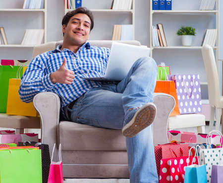 Young man after excessive shopping at homeの写真素材