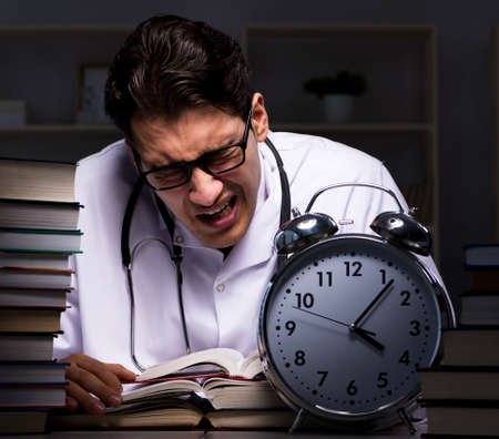 Medical student preparing for university exams at nightの写真素材