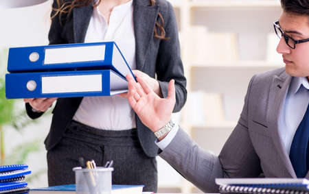 Businessman asking for paperwork from his assistant secretary